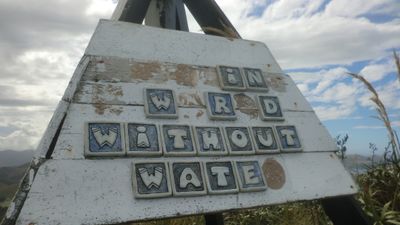 Pottery lettering on a trig station; missing letters mean we can read only ____IN_ _ W_R_D WITHOUT WATE_.